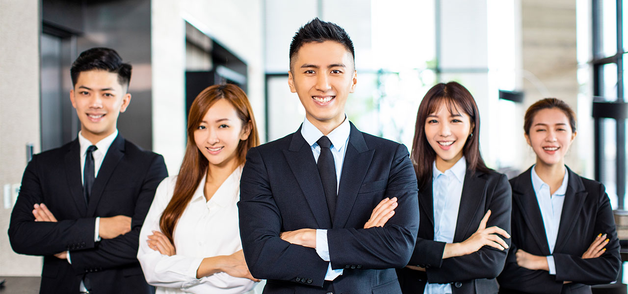 confident asian business team stands in office